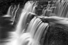 B&W photograph of waterfall showing slow shutter speed motion blur